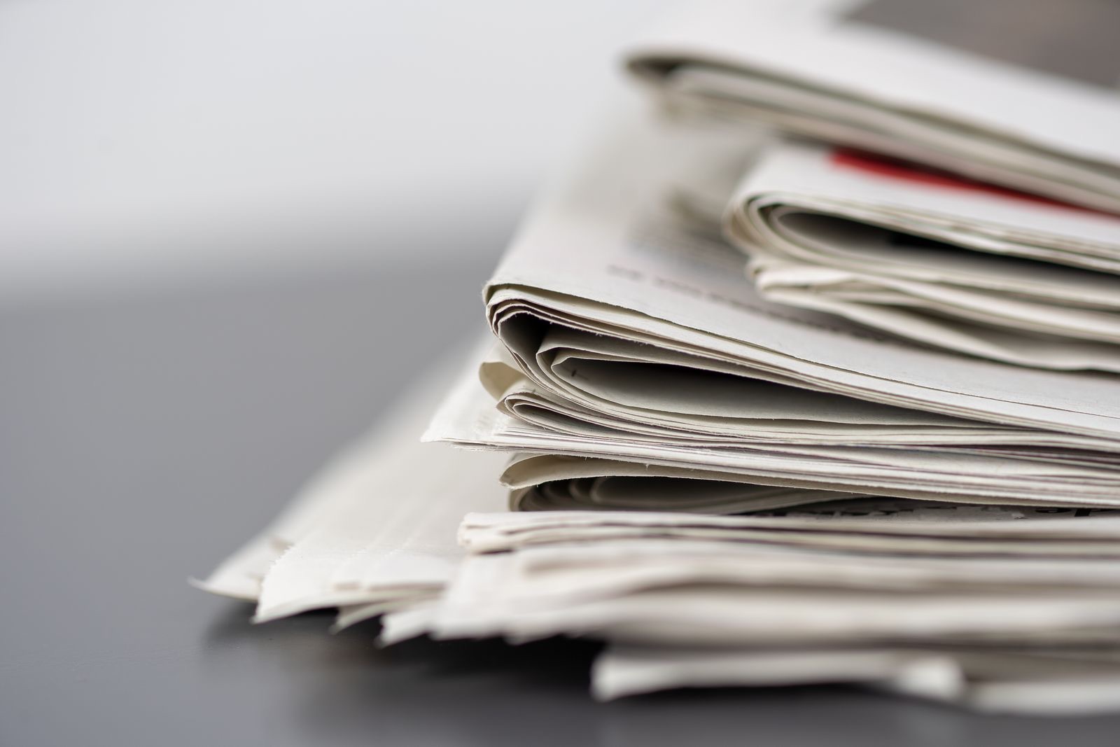 Stack of folded printed newspapers representing press coverage and print journalism