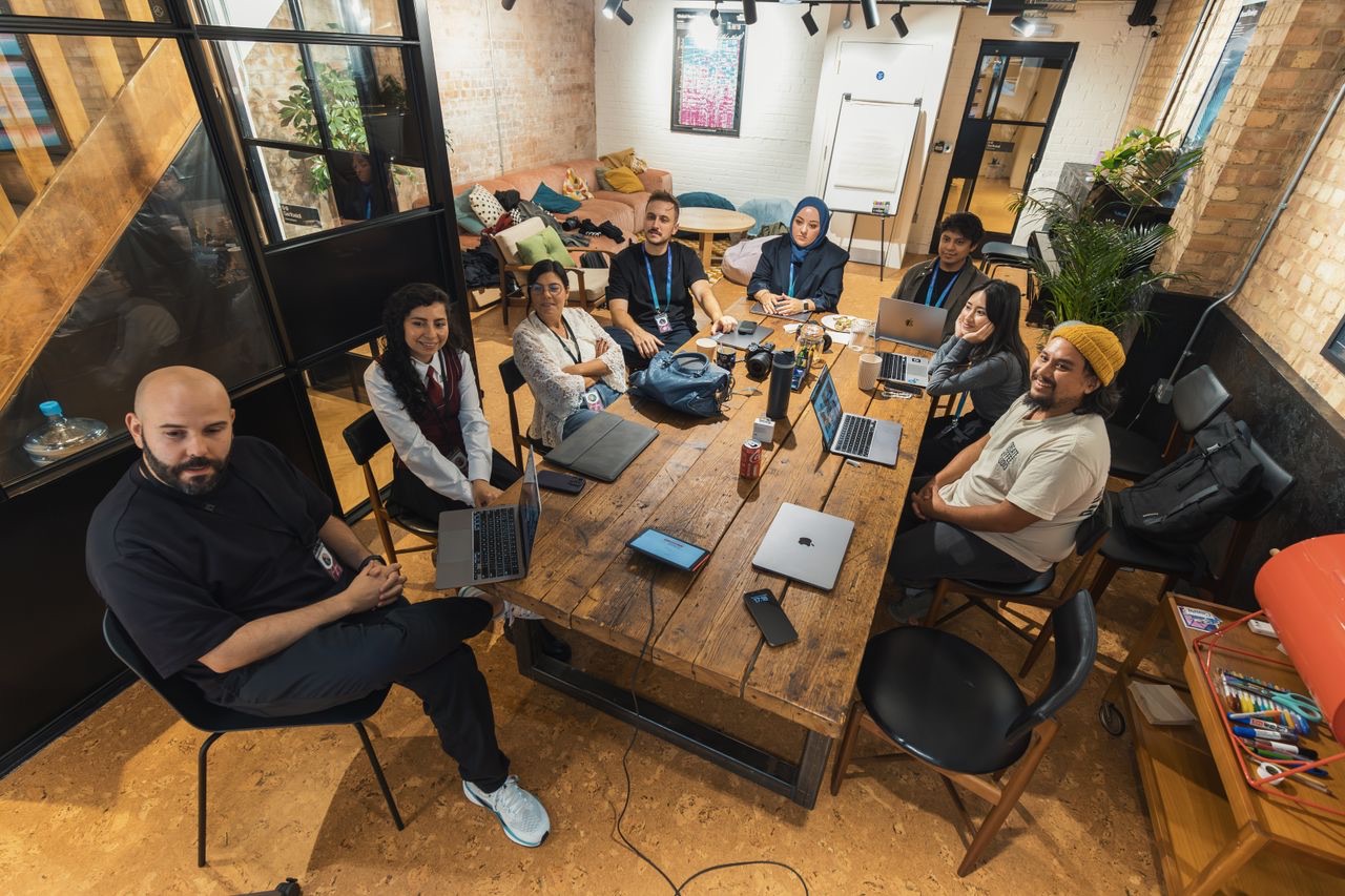 Diverse B2B team collaborating around laptops in a bright modern open-plan office