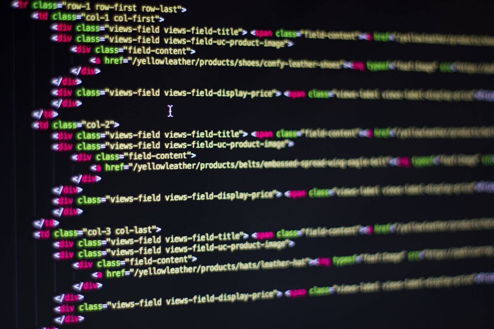 Close-up of a computer monitor displaying clean, syntax-highlighted HTML markup code in a developer's editor